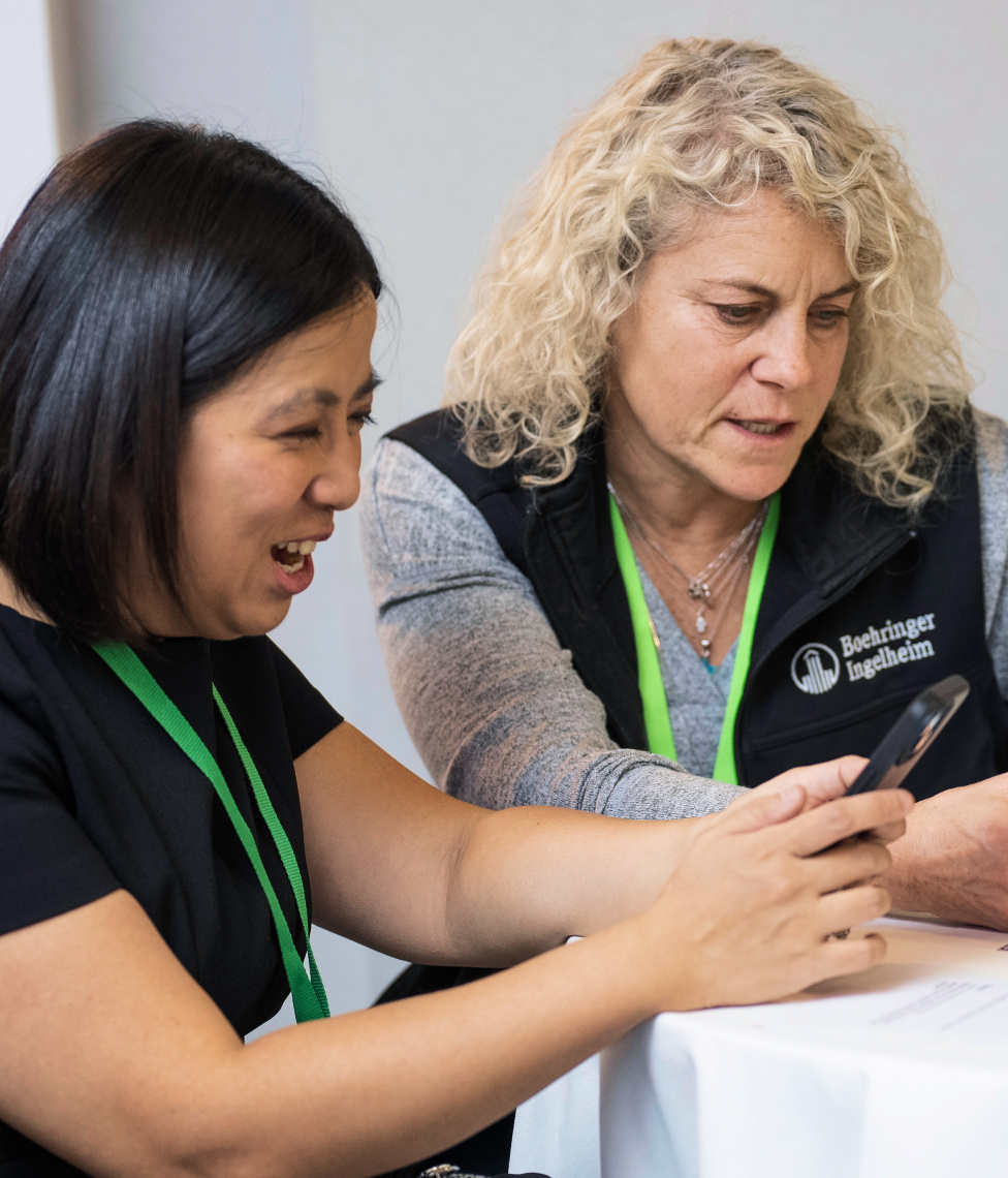 Two employees at a volunteering event Two employees at a volunteering event